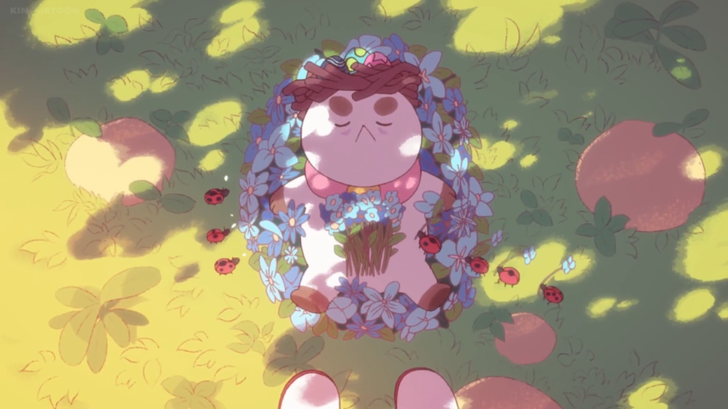котик лежащий на траве с цветами и божьими коровками